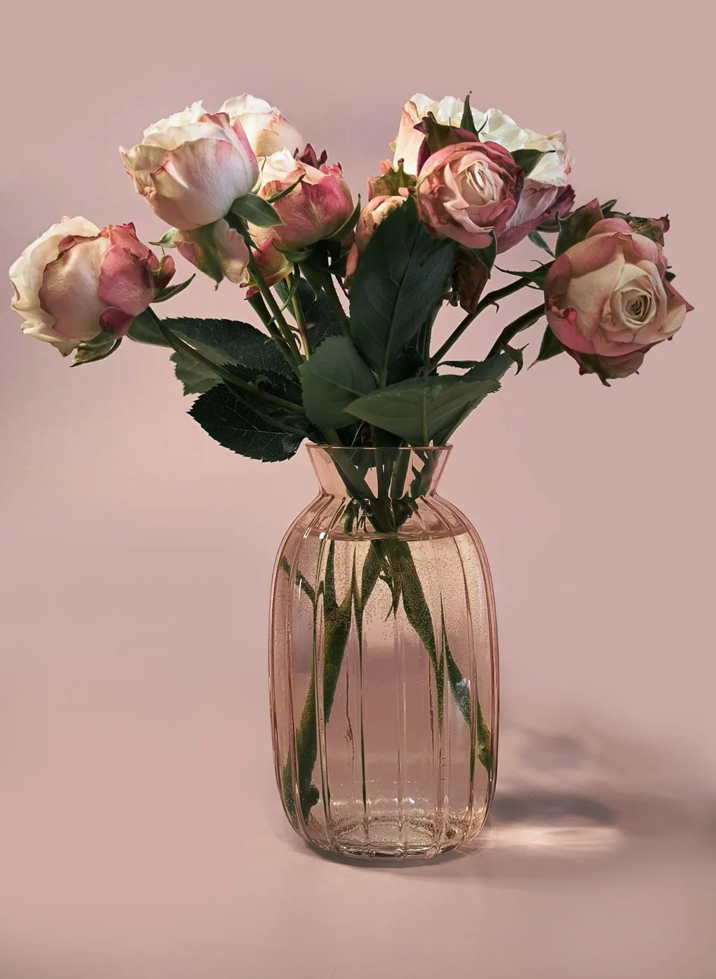 Bouquet de roses roses et crème dans un vase en verre